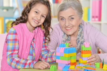 Naklejka premium Portrait of cute girl and grandmother playing
