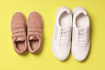  shoes for children and women's sneakers on a colored background top view. Footwear for children and adults.