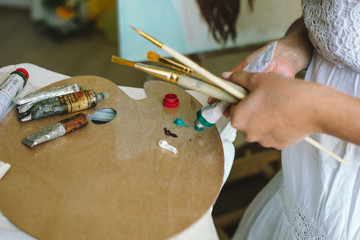 Obraz premium Artist paints picture on fabric with acrylic paints in her workshop