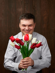 Man holds red flowers bouquet