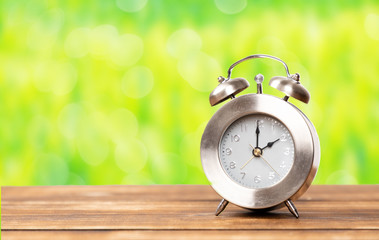clock for summer time change with green garden background