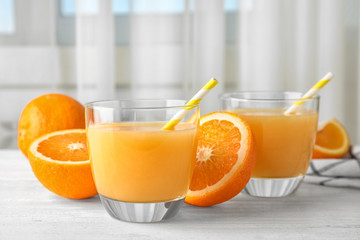 Composition with orange juice and fresh fruit on table