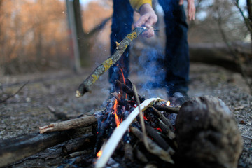 The hands of the person at the fire in the forest