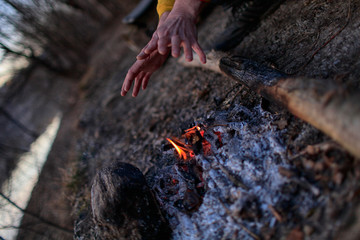 The hands of the person at the fire in the forest