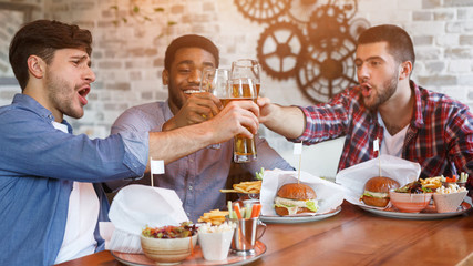 Enjoying beer with friends. Men resting in bar