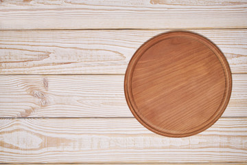 Pizza board on a wooden background, top view.