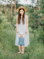 smiling mother and her daughter hugging on a walk on a sunny day