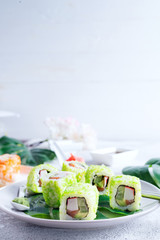 sushi roll with green caviar on a plate with chopsticks on stone background . Sushi menu. Japanese food copy space.