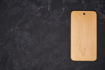 Old empty wooden  cutting board on black background, top view