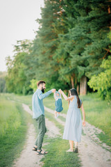 Naklejka premium Parents help their child make the first steps in life. Rear view