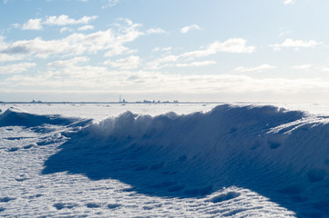 Snow wave on the Gulf of Finland with the Silhouette of the City in the Background