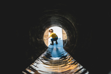 Young child sliding down a tunnel slide