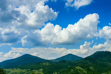 Obraz na płótnie Canvas hill tops in the mountains, beautiful blue sky with clouds