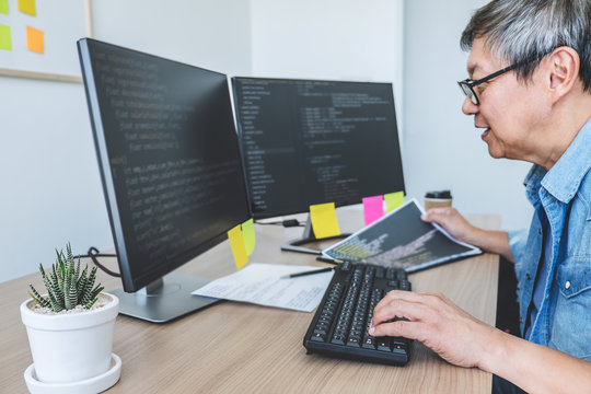 Senior Professional programmer working at developing programming and website working in a software develop company office, writing codes and typing data code