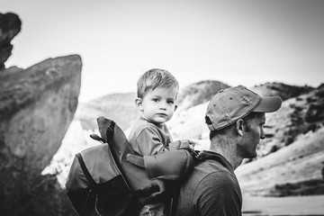 Father and son hiking and backpacking in the mountains in black and white.