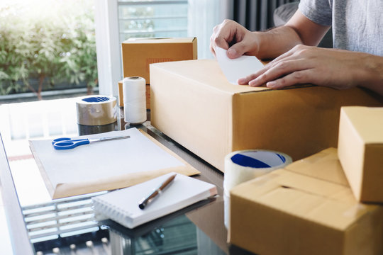 Young entrepreneur SME man receive order client and working with packaging sort box delivery online market on purchase order and preparing package product, Small business parcel for shipment