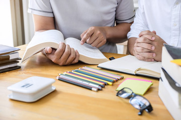 High school tutor or college student group sitting at desk in library studying and reading, doing homework and lesson practice preparing exam to entrance, education, teaching, learning concept