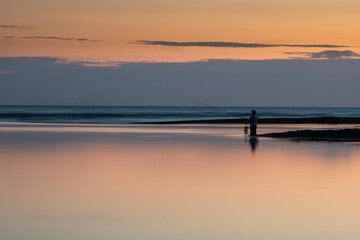 silhouette of a fisherman at the mouth of the Sele river at sunset, Salerno, Campania, Italy