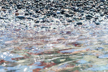 	Seaside with  the wet sparkling pebbles. 