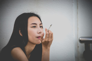 Obraz premium Asian woman sad from love,She smoking because stress from boyfriend,Heartbreak woman concept
