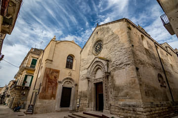 Fototapeta na wymiar ALTAMURA, ITALY - AUGUST 26, 2018: Amazing church of St. Nicholas of the Greeks or Saint Nicola in Altamura. Apulia. Italy. Dreamy summer afternoon with cloudy sky. View from below, street perspective