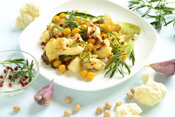 Roasted cauliflower with chickpeas, zucchini noodles and rosemary, salad