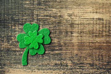 Decorative leaf of clover, trefoil, shamrock leaves on wood background, close up. Happy St. Patrick's Day holiday symbol.