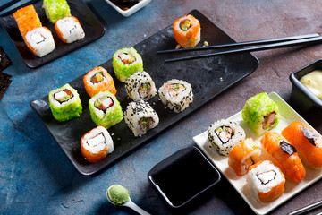 Traditional Japanese food- sushi, rolls, chopsticks, soy sauce on color stone background. Sushi menu.