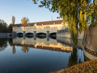 Obraz premium Oberföhringer Wehr in der Abendsonne mit Spiegelung im Wasser, Englischer Garten, München