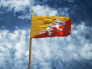 Bhutan flag Silk waving flag of Bhutan made transparent fabric with wooden flagpole gold spear on background sunny blue sky white smoke clouds real retro photo Countries of world 3d illustration