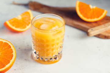 Fresh orange juice with ice cubes in a glass on a table. The concept of healthy eating.