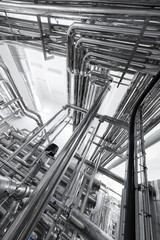 Steel water pipeline, chrome pipes, pipe lines in plant workshop. Industrial background