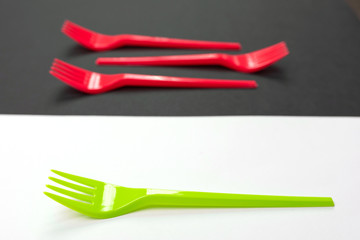 Bright green and red forks isolated on black and white background