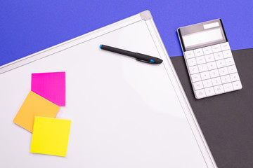 Modern workplace with notebook, pen and calculator isolated on blue black background