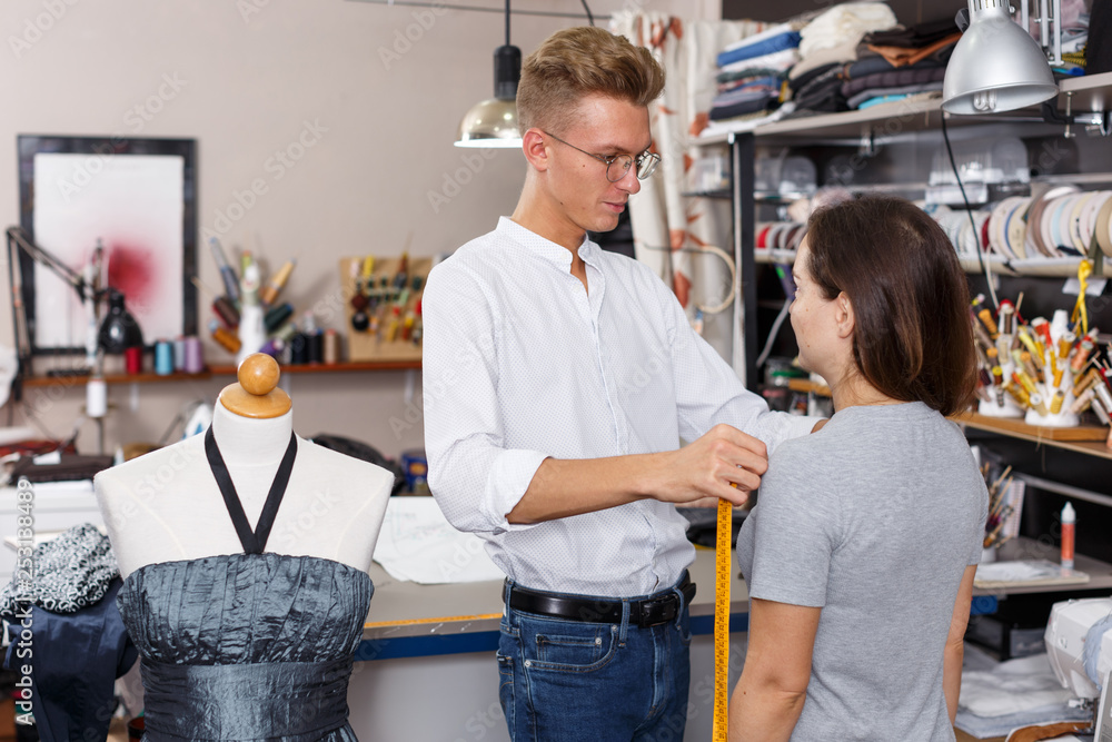 Poster tailor using tape measure for taking measurements