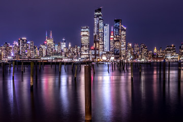 Fototapeta na wymiar New York City Manhattan Midtown Panorama at Night with Skyscrapers illuminated over Hudson River.