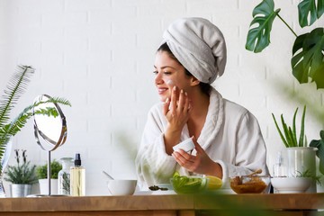 Fototapeta na wymiar Young woman cleaning face with natural cosmetics. Clean fresh skin care.