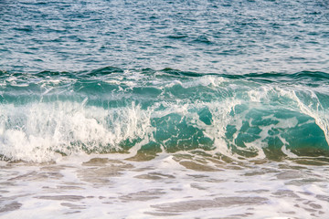 Tidal bore. Blue waves with bats rolling onto a sandy beach