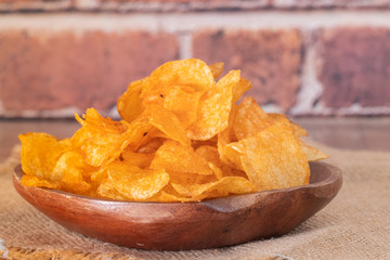 close up of Crispy potato chips on wooden bowl