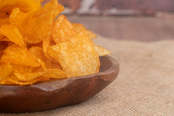 close up of Crispy potato chips on wooden bowl