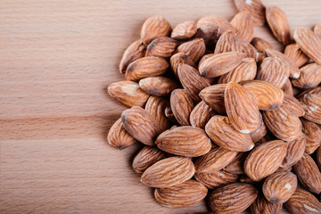 Close up pile of almonds on wooden floor,background.