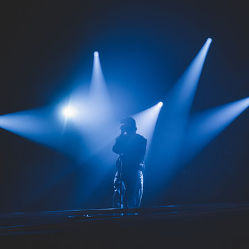 Chanteur avec pied de micro et jeux de lumi&egrave;re sur sc&egrave;ne