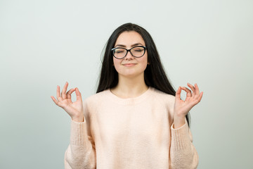 Emotional portrait of a dark-haired girl on a gray background, stormy emotions, business concept.	