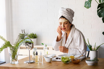 Young woman cleaning face with natural cosmetics. Clean fresh skin care.