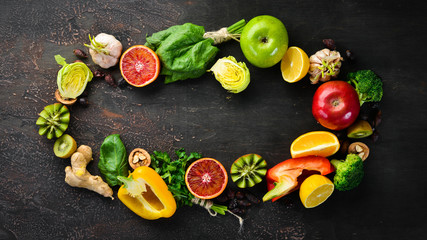 Healthy vegetarian food: Orange, lemon, apple, rose, garlic, broccoli, apple, kiwi, spinach. Top view. free space for your text.