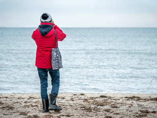 Young man on the beach wachting birds life using telescope