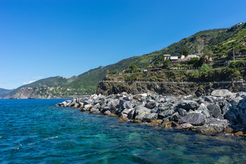 Fototapeta na wymiar Italy,Cinque Terre,Riomaggiore, a large body of water with a mountain in the background