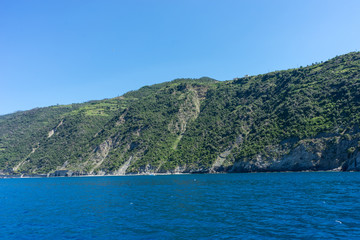 Fototapeta premium Italy,Cinque Terre,Riomaggiore, a large body of water with a mountain in the background