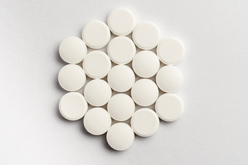 Fototapeta na wymiar Close up of a group of white pills on white background, beautifully arranged, top view