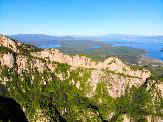 Aerial view of mountain with water reservoir  on the background. Mountain peak with beautiful blue sky and green forest. Landscape of mountain in natural reserve park. Miyun, Beijing, China.